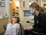 Dentist chats with patient during a procedure